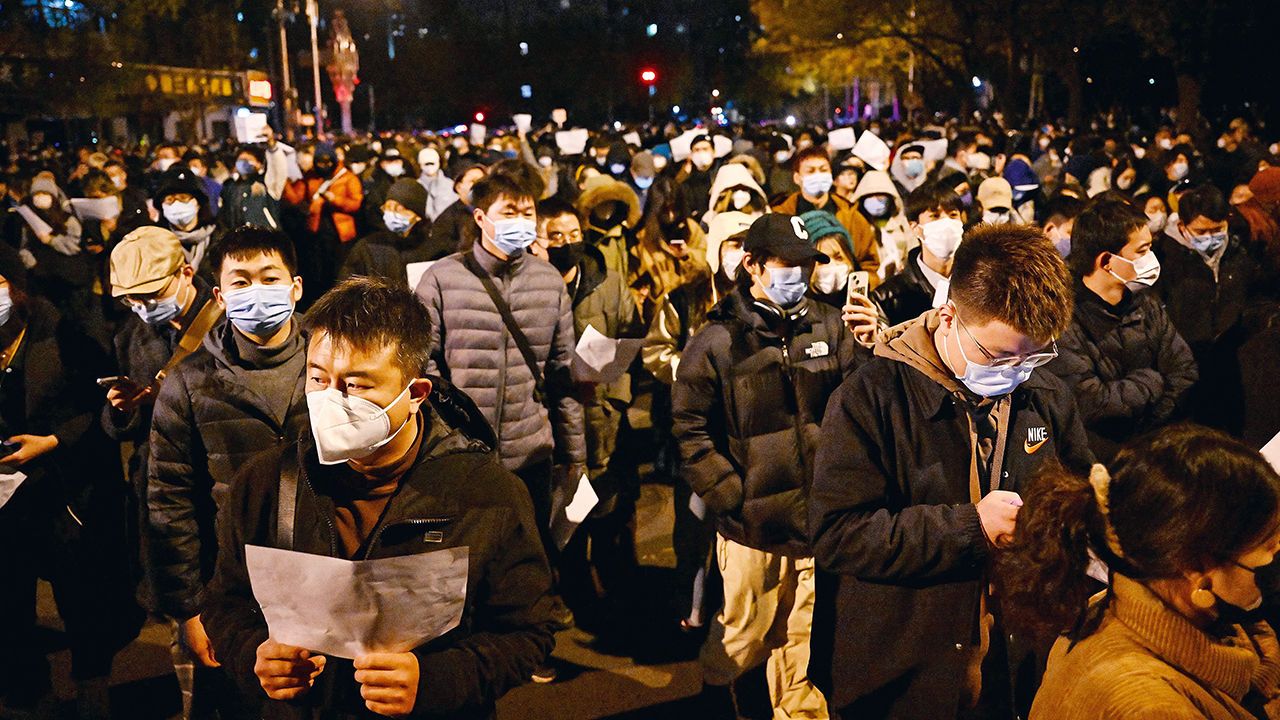 Protesters march along a street during a rally for the victims of a deadly fire as well as a protest against China's harsh Covid-19 restrictions in Beijing on November 28th 2022