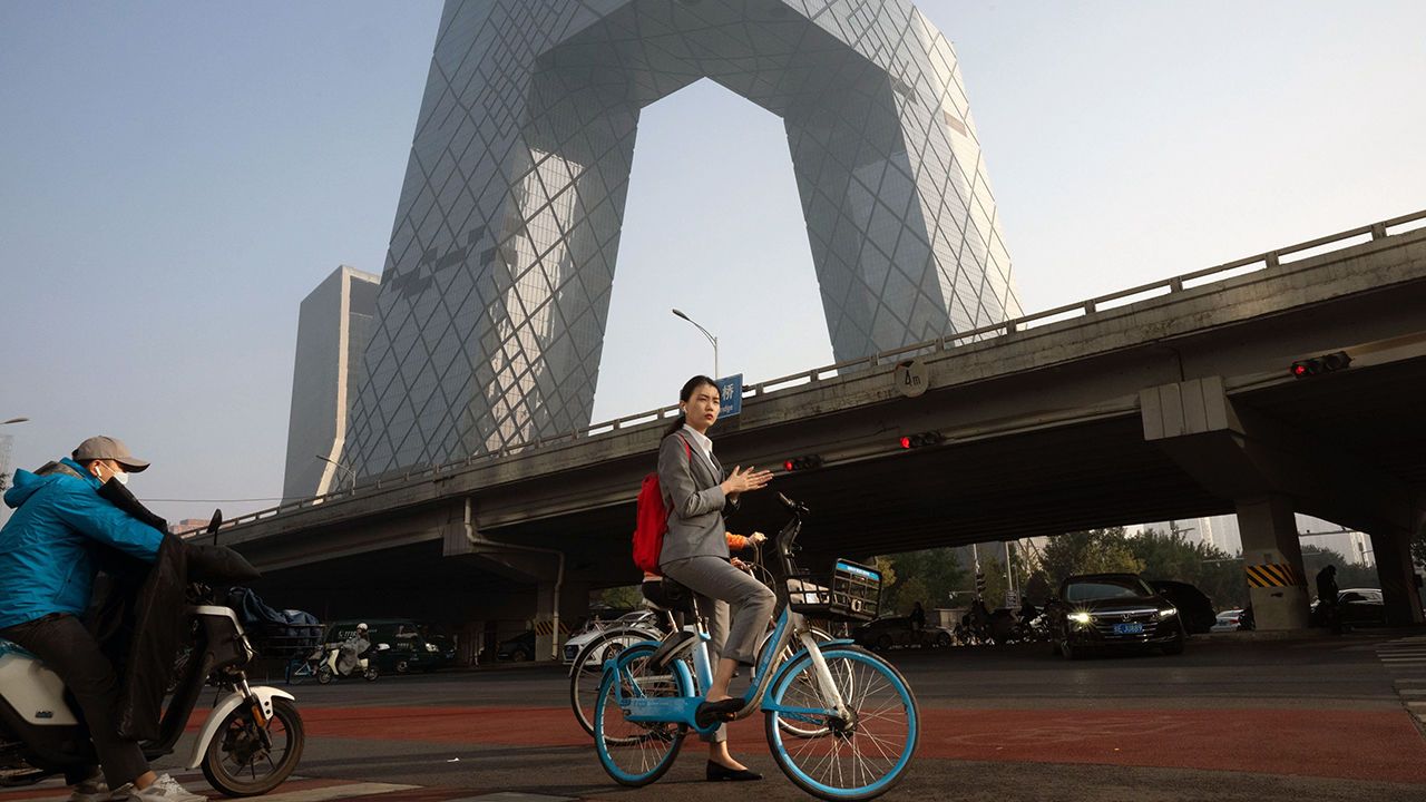 A morning commuter on a bicycle near the CCTV tower in Beijing, China