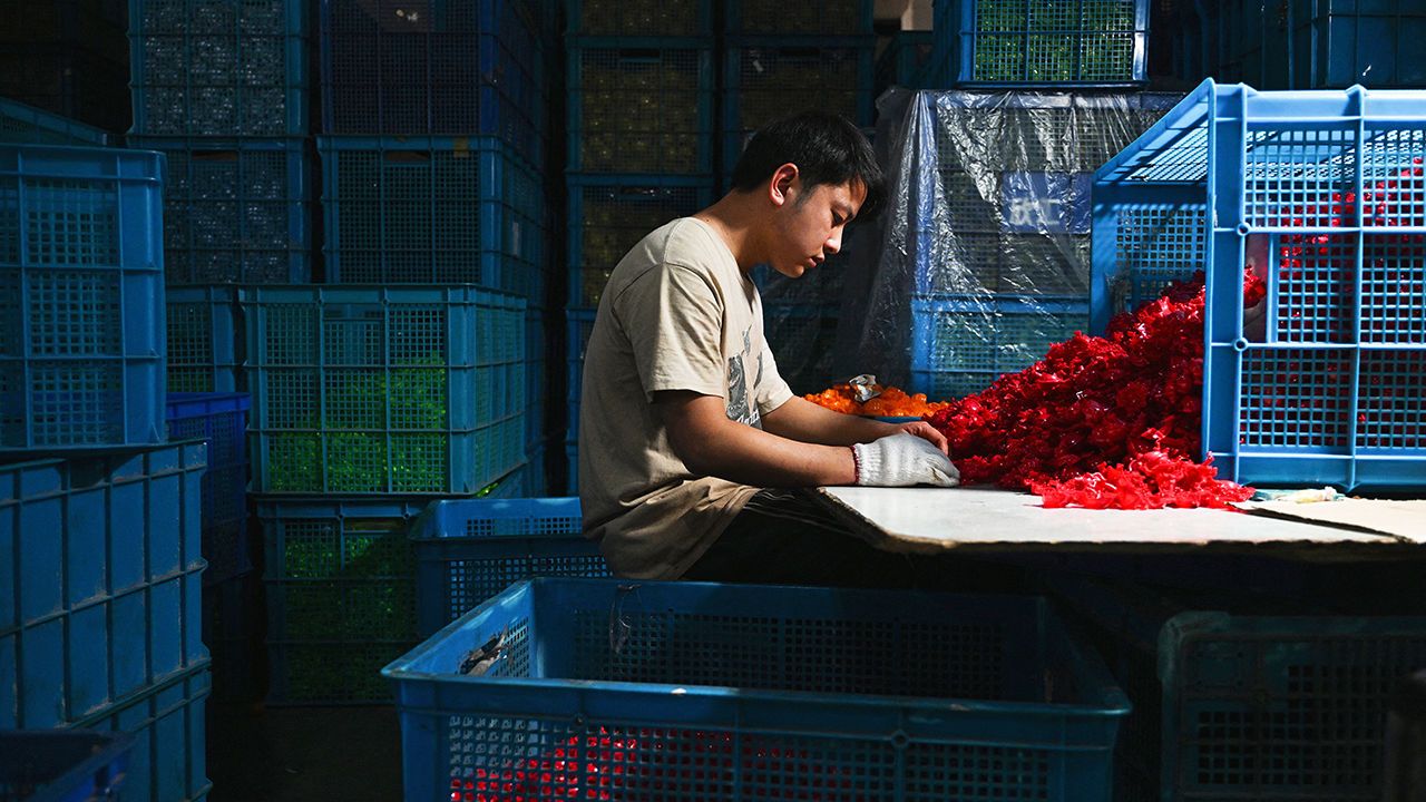 An employee works at a toy factory specialising in solar powered plastic gadgets in Yiwu.