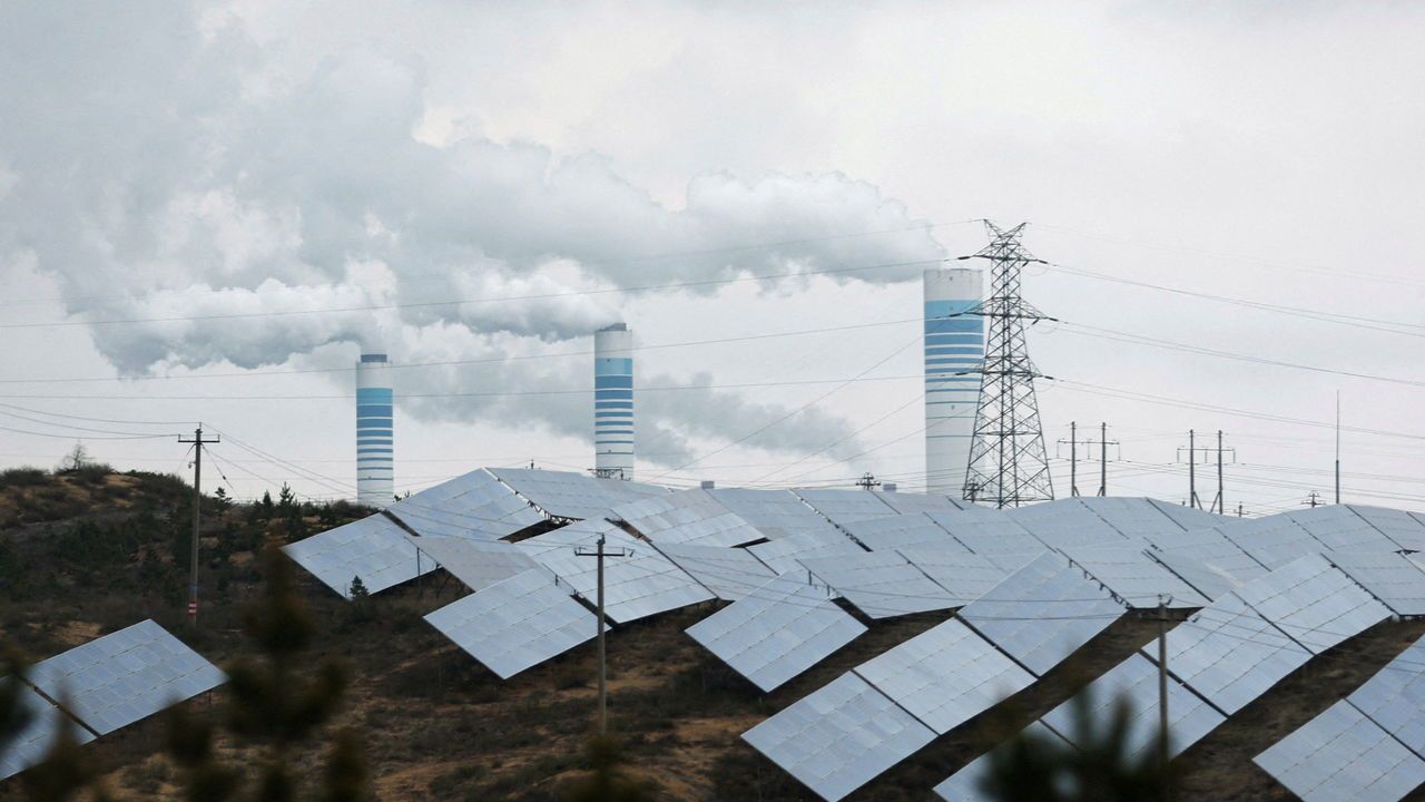 Smoke rises from chimneys near solar panels in China