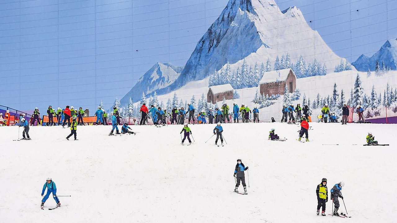 People enjoying skiiing at an indoor ski resort at Sunac Snow Park, Guangzhou, China